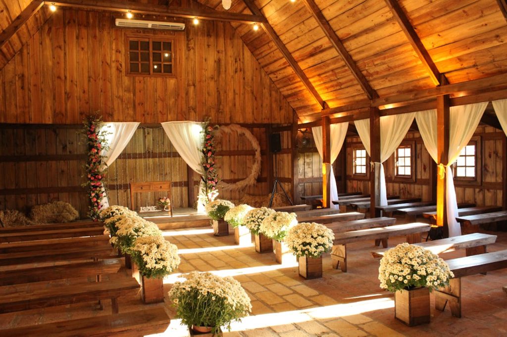 Charming wooden barn decorated for a wedding with floral arrangements and soft lighting.