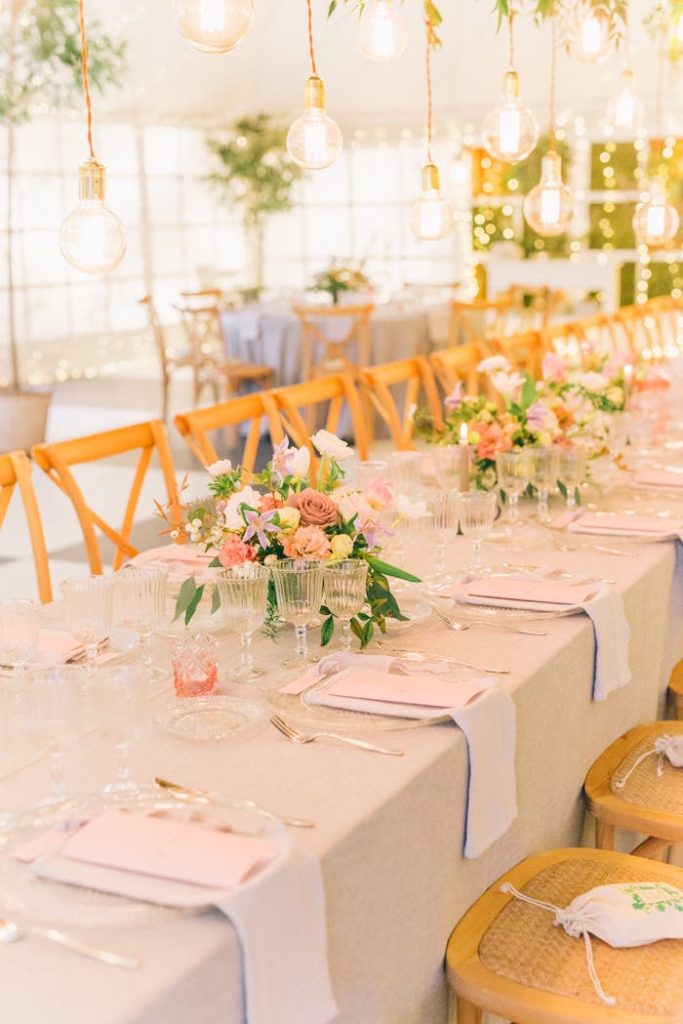 Stylish wedding table setting with floral arrangements and warm lighting.